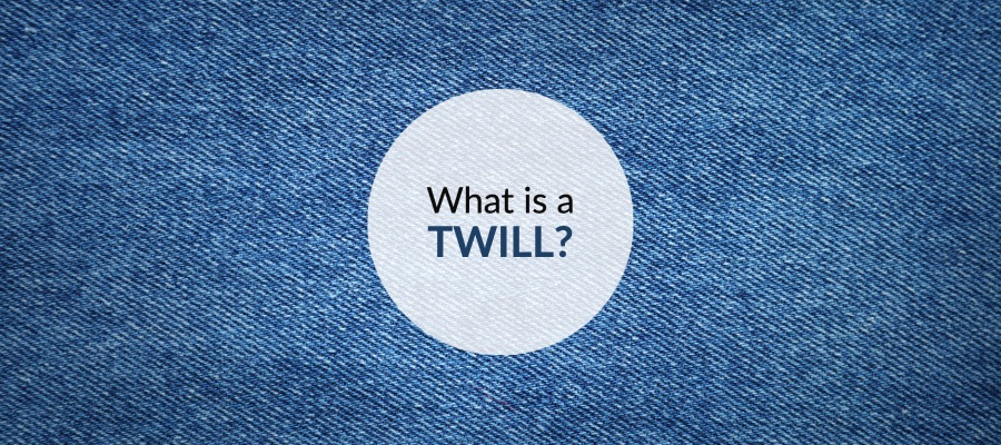 Denim backgroung with a white circle with text inside that reads What is a Twill?