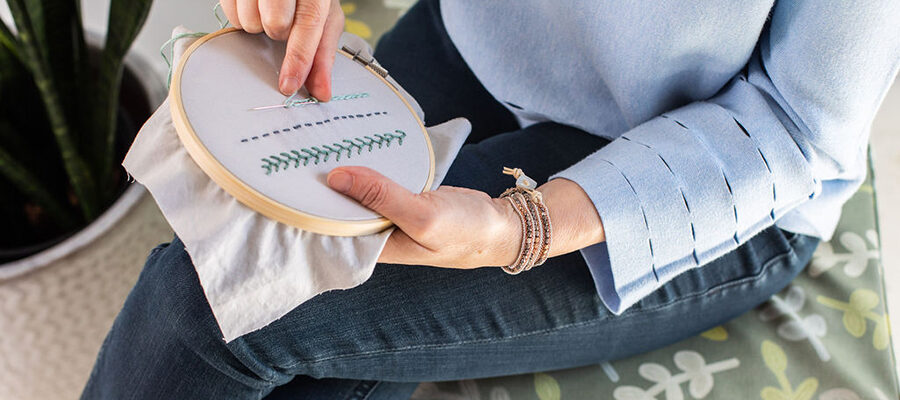 Woman sitting on stool embroidering. Photo only shows her hands.|Example of brush and color palettes in Illustrator used to create Invisible Threads collection.