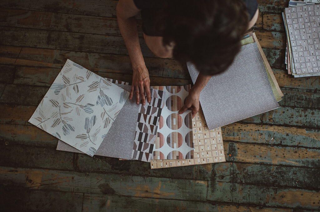 Photo of Kristen Dettoni spreading out fabric swatches on the ground.