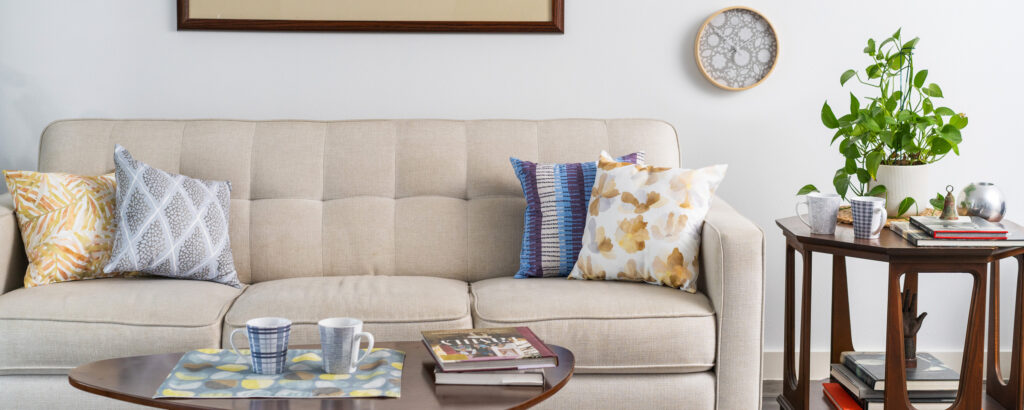 A couch in an apartment with a variety of products printed by Domanda Design with a patterns by Design Pool.