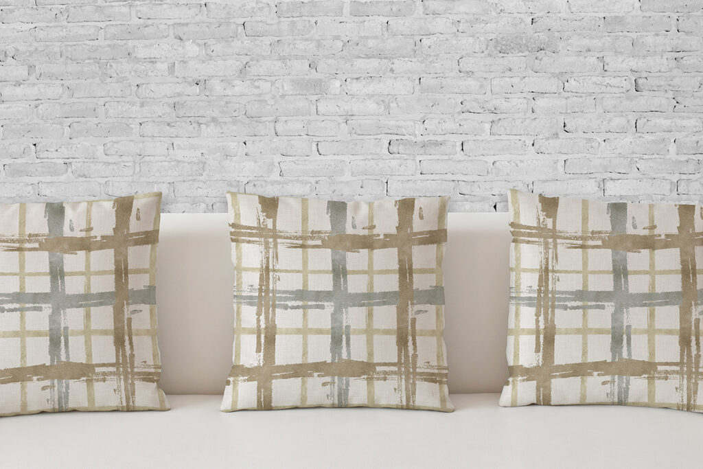 A mockup of Design Pool pattern Painted Tartan on pillows on a couch.