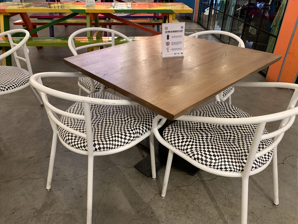 A photo of a table at Six Point Brewery with four chairs upholstered with Design Pool pattern Contort.