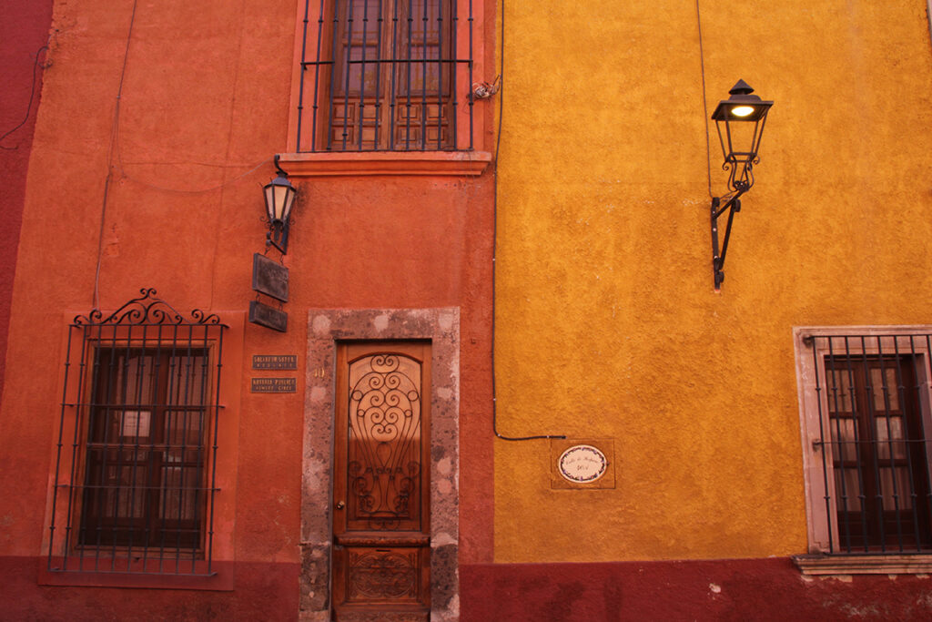 Photo of a wall in San Miguel de Allende with brightly colored buildings, taken by David Hansen. 