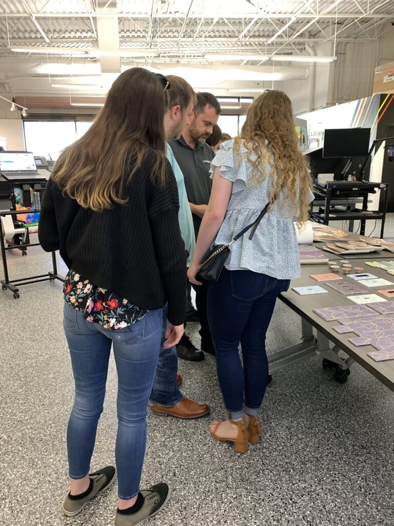 Women watching demo of digital printing.