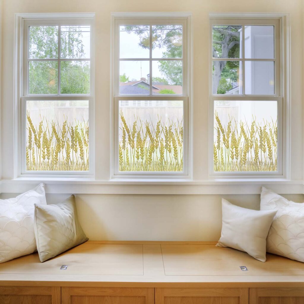 Window seat in home with woven window film on windows printed with a Design Pool pattern of stylized wheat.