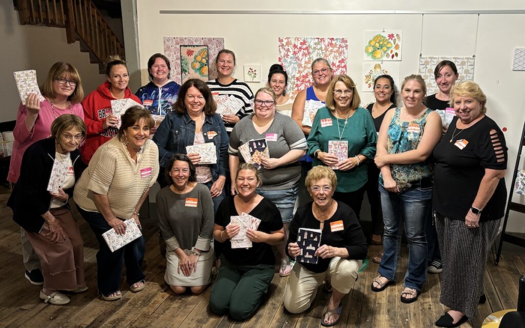 Group photo of attendees from the bookmaking and wine event with Kristen Dettoni and Dayna Hartford.
