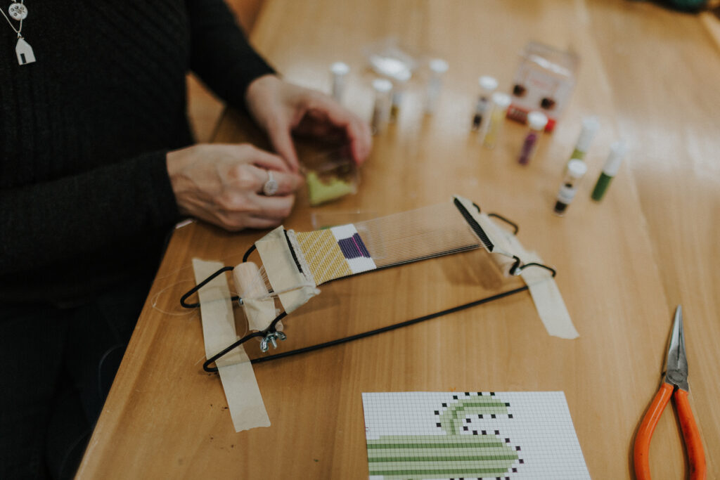 Kristen Dettoni working on a bead weaving.